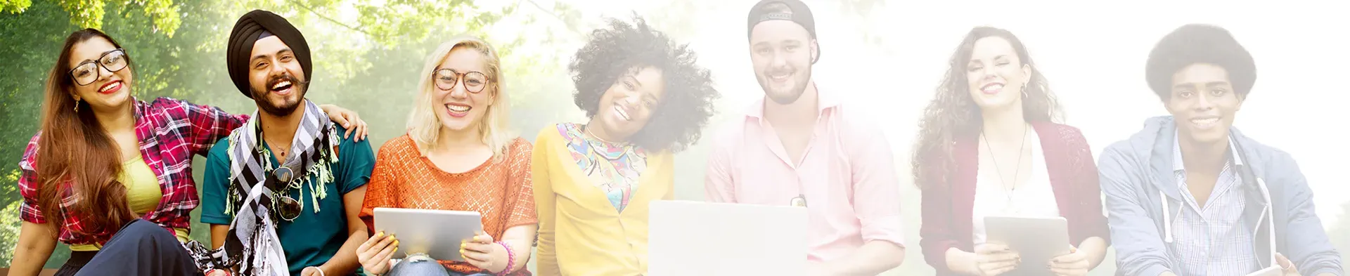 Group of diverse college students smiling with laptops